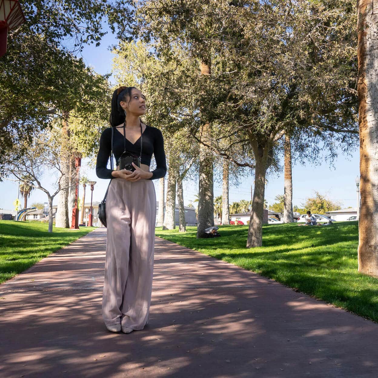 A young woman walks in a park.
