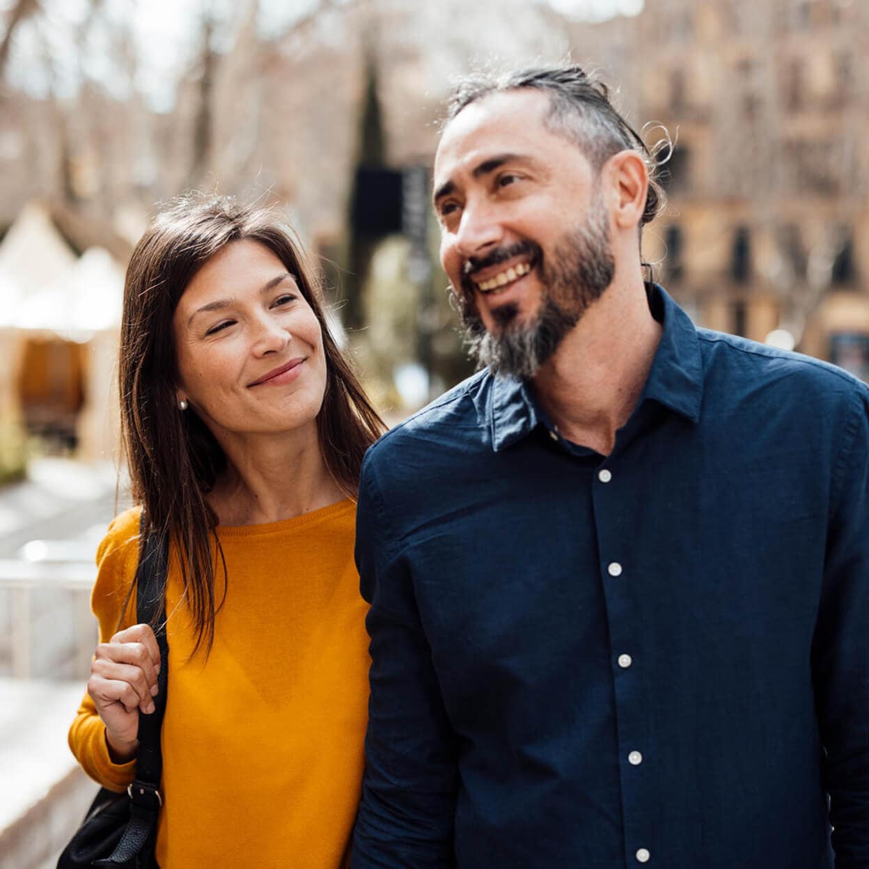 A couple smile while walking down the street